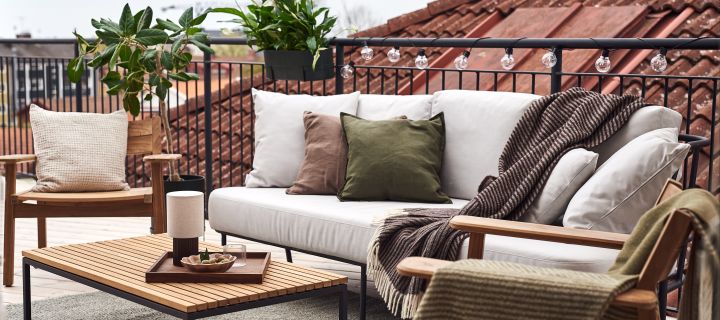 Dekorer din balkon med hyggelige uldtæpper og puder fra NJRD, Ernst, Himla og Scandi Living for at gøre din balkon lidt mere hyggelig.