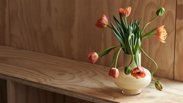 Indretningstips og de nyeste indretningstrends at læse om hos Nordic Nest. Her en gul vase fra Marimekko med orange tulipaner i. 