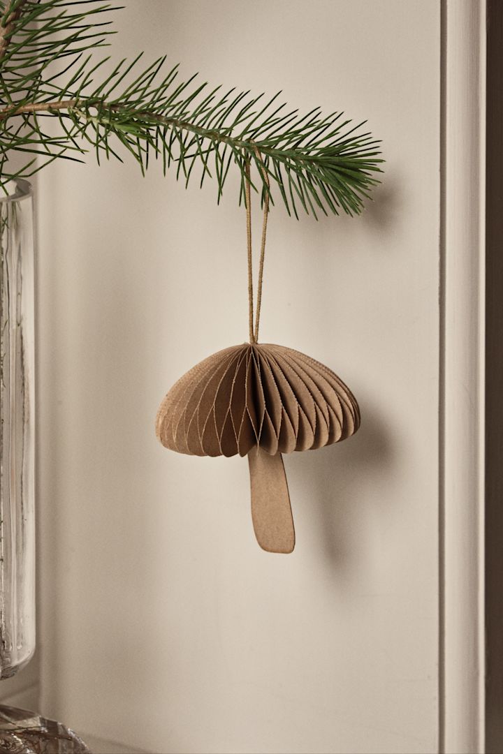 Naturinspirerede ideer til juletræspynt som svampedekorationen Fungi fra Broste Copenhagen, der ses her hængende på en gren. 