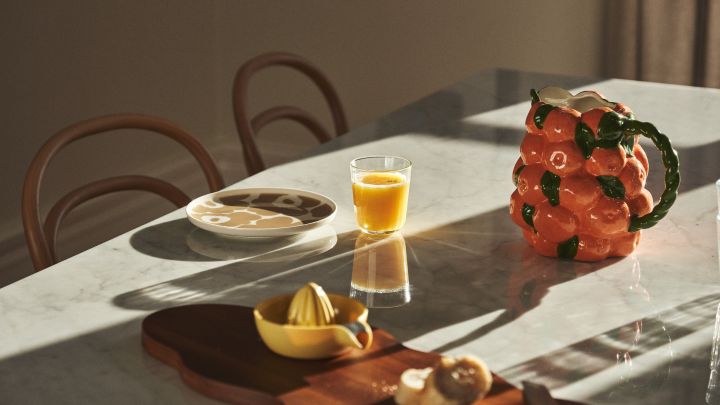 Bordstel med Marimekko-porcelæn, juice og karaffel fra BYON i design af mandariner. 