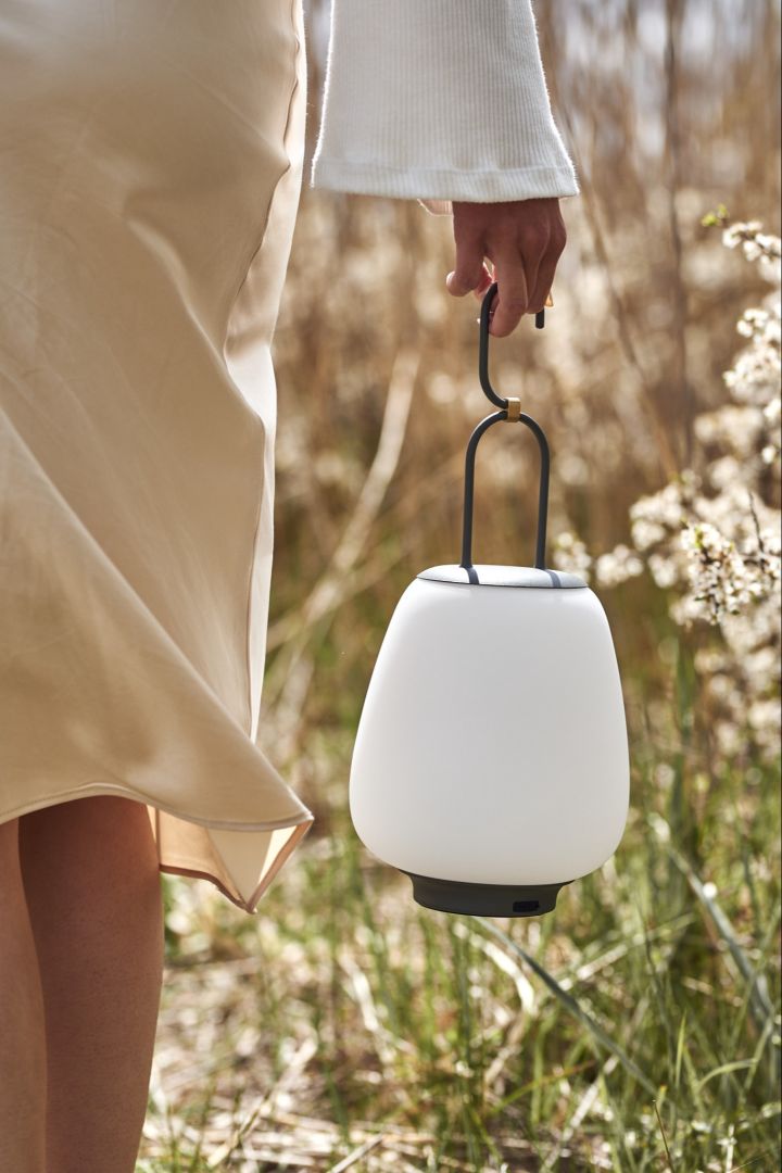 Den trådløse bordlampe Lucca fra &Tradition båret på en strand.