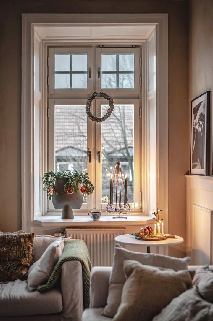 Den svenske influencer @hannesmauritzson har dekoreret sit meget høje vindue med en julekrans, vindueskarmen er pyntet med gran og Season Extention-lysestagen fra Georg Jensen.