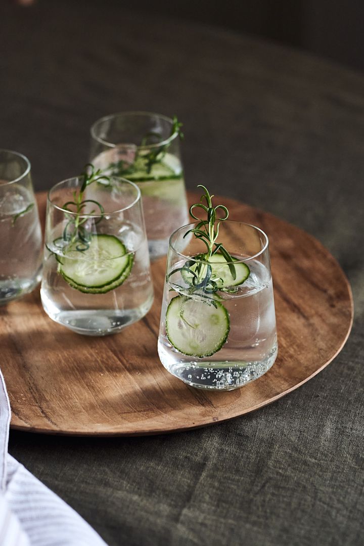 4 festlige cocktailopskrifter til nytår - Iittala Essence vandglas på Muubs Teak-tallerken.