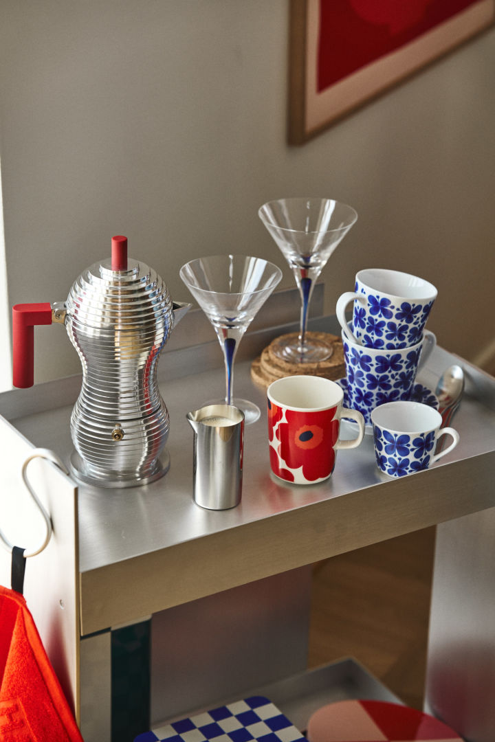 Her ser du en retro inspireret kaffestation i krom med kopper i rød og blå sammen med cocktailglas i blå, nostalgisk indretning er en af de store indretningstrends i efterårets indretningstrender 2024.