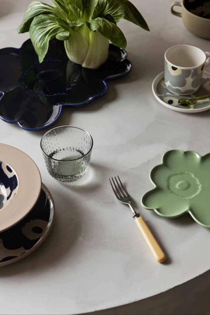 Sæt med Unikko-porcelæn fra Marimekko, bl.a. to blomsterformede tallerkener i mintgrøn og mørkeblå.