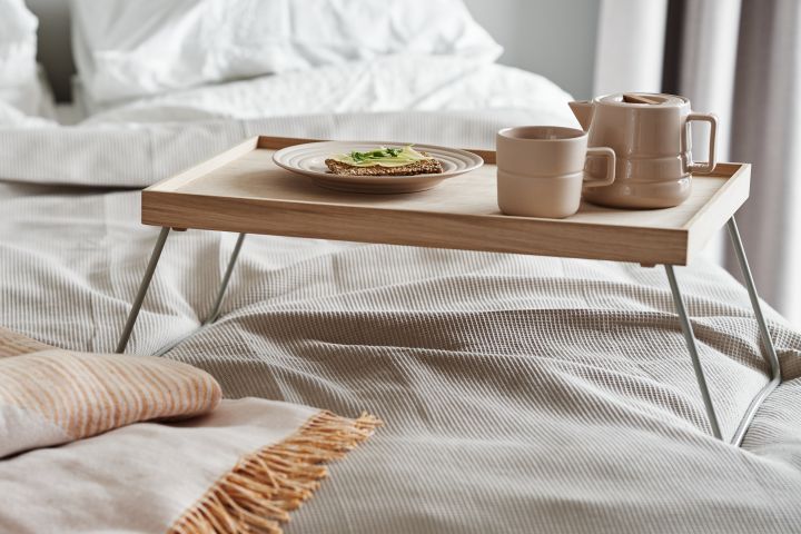 Taktile beige porcelæn fra NJRD er den perfekte makker til morgenmad i sengen sammen med et blødt genanvendt bomuldstæppe.