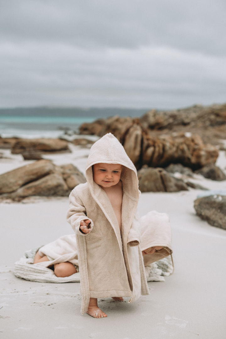 Badehåndklæder med hætte som Sand Terry-hættehåndklædet fra Garbo&Friends holder babyen varm, selv efter badet, hvor der er særlig risiko for at fryse. Derfor er badehåndklæder som dette en god gave til babyshower.