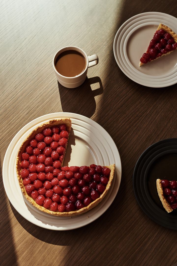 NJRD lines tallerken i beige med en kirsebær tærte og en kop kaffe.