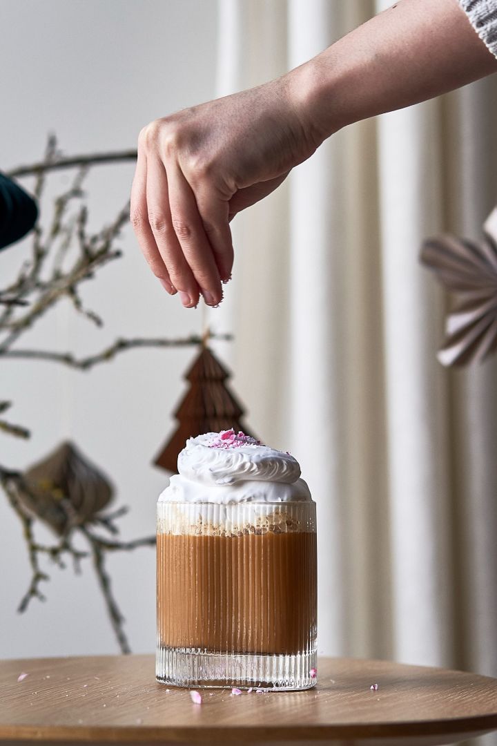 Byd dine venner og familie på en enkel julecocktail i år. Her ser du en kaffecocktail pyntet med flødeskum og candy cane i Ripe glasset fra Muubs.